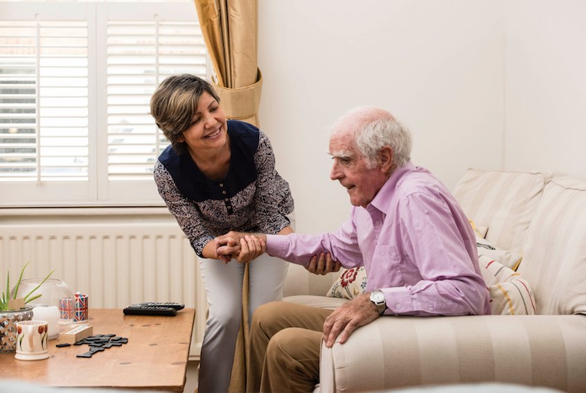 Compassionate carer supporting elderly client at home